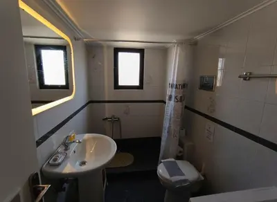 a small bathroom with a sink and a toilet at Aiolos - Faliro Haven in Athens