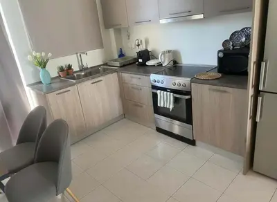 a kitchen with wooden cabinets and a stove at Aiolos - Faliro Haven in Athens