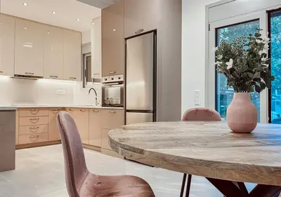 a kitchen with a table and chairs and a vase with flowers at Athens Riviera City Escape in Athens
