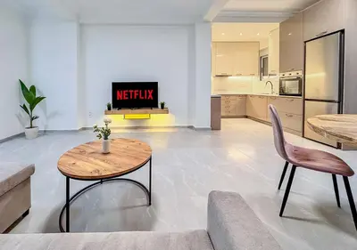 a living room with a table and a kitchen at Athens Riviera City Escape in Athens