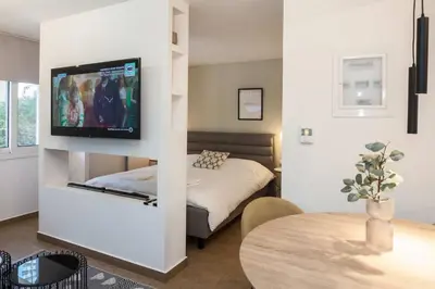 a bedroom with a bed and a tv on a wall at Fresh Modern 1 Bd Apt in Quiet Agia Paraskevi in Athens
