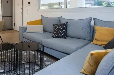 a living room with a blue couch with pillows at Fresh Modern 1 Bd Apt in Quiet Agia Paraskevi in Athens