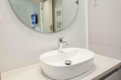 a white sink in a bathroom with a mirror at Fresh Modern 1 Bd Apt in Quiet Agia Paraskevi in Athens