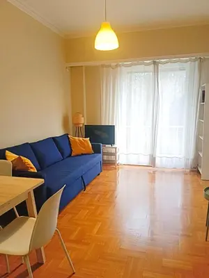 a living room with a blue couch and a table at Charming Plaka Retreat in Athens in Athens