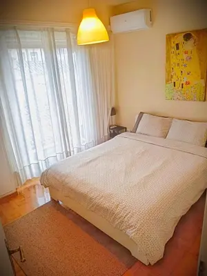 a bedroom with a large white bed with a window at Charming Plaka Retreat in Athens in Athens
