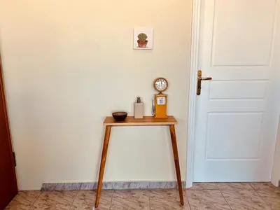 a table with a clock on it next to a door at Acropolis View Funky House in Athens