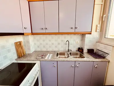 a kitchen with white cabinets and a sink at Acropolis View Funky House in Athens