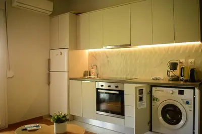 a kitchen with a refrigerator and a washing machine at 2BA under the Acropolis Hill Athens City Center in Athens