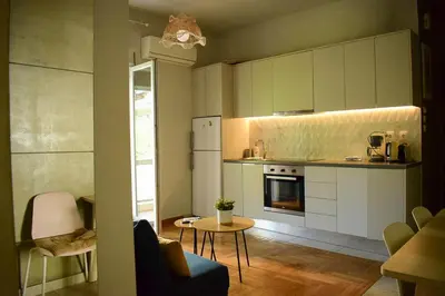 a kitchen with white cabinets and a table and a table sidx sidx sidx at 2BA under the Acropolis Hill Athens City Center in Athens