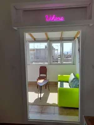 a living room with a green couch and a chair at Sunny Penthouse in the Center of Athens in Athens