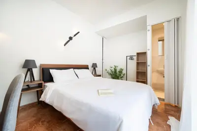 a white bedroom with a white bed and a mirror at Houseloft The Viewpoint Athens in Athens