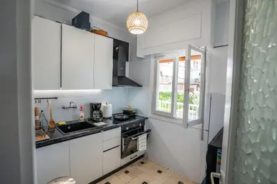 a kitchen with white cabinets and a sink and a window at Beachfront Lagonisi Apt 1 Minute From Grand Resort in Kalívia Thorikoú