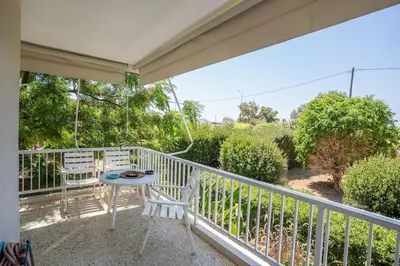 a patio with a table and chairs on a balcony at Beachfront Lagonisi Apt 1 Minute From Grand Resort in Kalívia Thorikoú