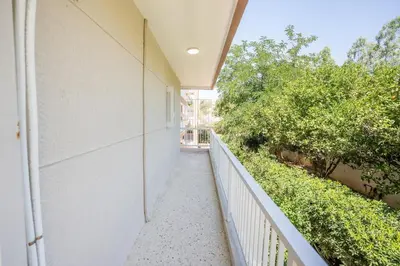 a balcony with a white fence and trees at Beachfront Lagonisi Apt 1 Minute From Grand Resort in Kalívia Thorikoú
