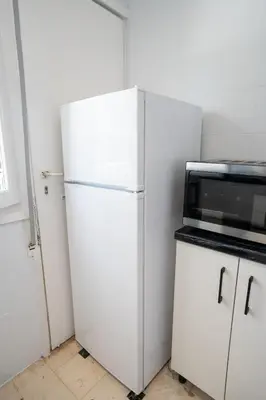 a white refrigerator in a kitchen with a microwave at Beachfront Lagonisi Apt 1 Minute From Grand Resort in Kalívia Thorikoú