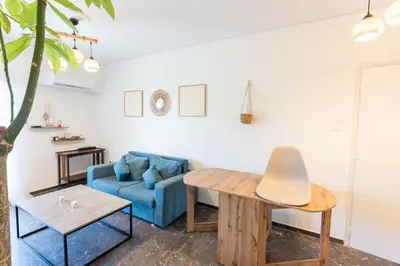 a living room with a blue couch and a table at Beachfront Lagonisi Apt 1 Minute From Grand Resort in Kalívia Thorikoú