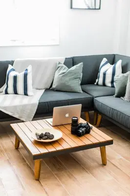 a living room with a couch and a coffee table with a laptop at Quiet room, hall, shared bathroom and kitchen in Athens