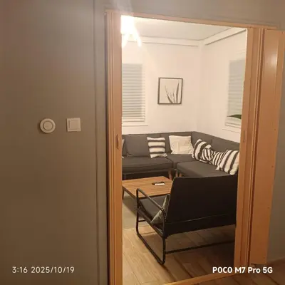 a living room with a couch and a table at Quiet room, hall, shared bathroom and kitchen in Athens