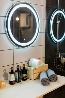 a bathroom with a shelf with towels and a mirror at Quiet room, hall, shared bathroom and kitchen in Athens