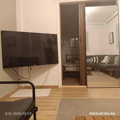 a living room with a large flat screen tv on the wall at Quiet room, hall, shared bathroom and kitchen in Athens