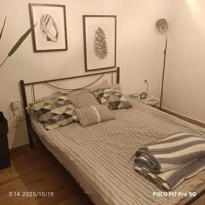 a bedroom with a bed with pillows on it at Quiet room, hall, shared bathroom and kitchen in Athens