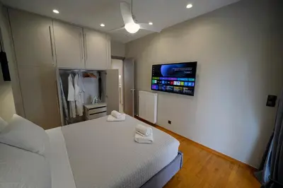 a bedroom with a bed and a tv on the wall at POSEIDON Executive Suite in Athens