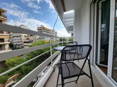 a balcony with two chairs and a table on it at POSEIDON Executive Suite in Athens