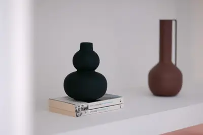 a green vase sitting on top of two books at Unique 2BD 2BA Design Apt with airconditioning near Acropolis in Athens