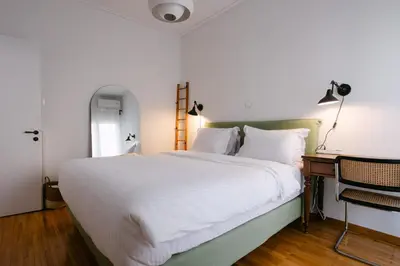 a bedroom with a large white bed and a desk at Unique 2BD 2BA Design Apt with airconditioning near Acropolis in Athens
