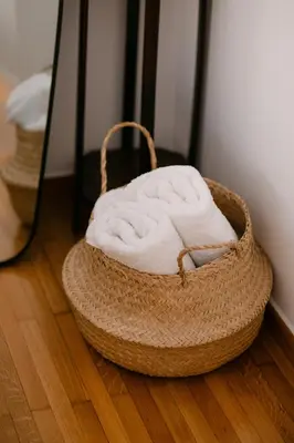 a basket filled with towels sitting on a wooden floor at Unique 2BD 2BA Design Apt with airconditioning near Acropolis in Athens