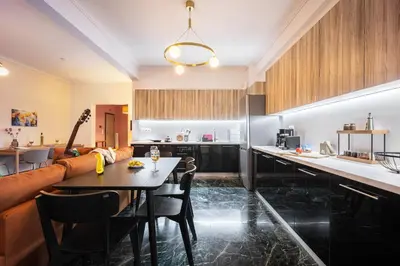 a kitchen and living room with a table and a couch at Stylish Luxury Getaway 3BR Apartment 115m in Athens
