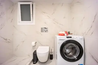 a white bathroom with a washing machine in it at Stylish Luxury Getaway 3BR Apartment 115m in Athens
