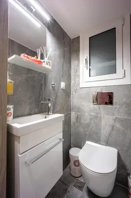 a bathroom with a toilet and a sink and a tv at Stylish Luxury Getaway 3BR Apartment 115m in Athens