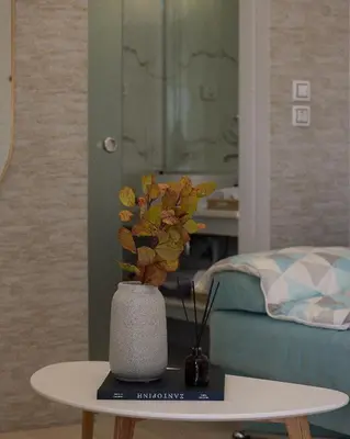 a table with a vase with flowers on it at Acropolis view modern studio in Athens
