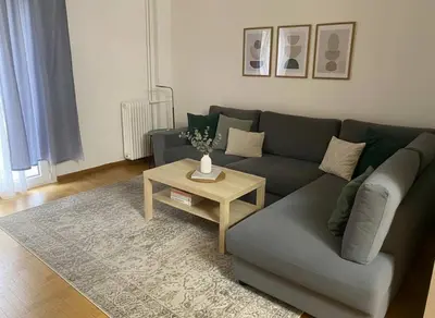 a living room with a couch and a coffee table at Lydia Apartment Comfortable 2BR near Hospital in Athens