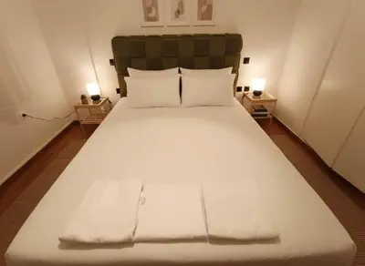 a bedroom with a large white bed with two lamps at Lydia Apartment Comfortable 2BR near Hospital in Athens