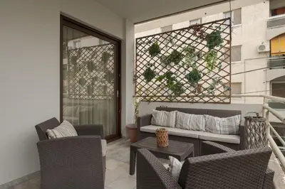 a living room with a couch and chairs on a balcony at Spacious & central 2BR apt in Agia Paraskevi in Athens