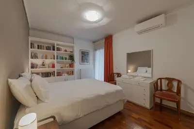 a bedroom with a bed and a desk and a television at Spacious & central 2BR apt in Agia Paraskevi in Athens