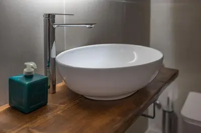 a white bowl sink on a wooden counter in a bathroom at Spacious & central 2BR apt in Agia Paraskevi in Athens