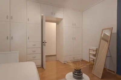 a room with white cabinets and a mirror and a table at Spacious & central 2BR apt in Agia Paraskevi in Athens