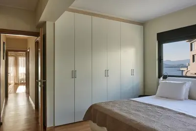 a bedroom with a bed and a large window at Deep Blue Luxury Escape Heated Pool & Sea View in Saronida