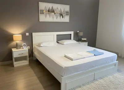 a bedroom with a large white bed and two night stands at Under the Gaze of the Acropolis 2-Bb Athenian Apt in Athens