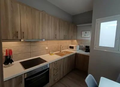a kitchen with wooden cabinets and a sink and a window at Under the Gaze of the Acropolis 2-Bb Athenian Apt in Athens