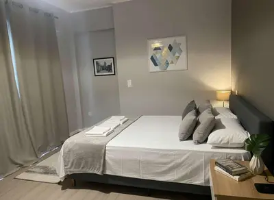 a bedroom with a bed with white sheets and pillows at Under the Gaze of the Acropolis 2-Bb Athenian Apt in Athens