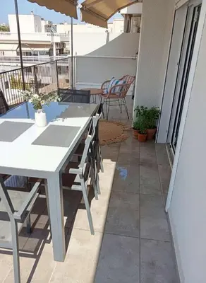 a patio with a table and chairs on a balcony at Under the Gaze of the Acropolis 2-Bb Athenian Apt in Athens