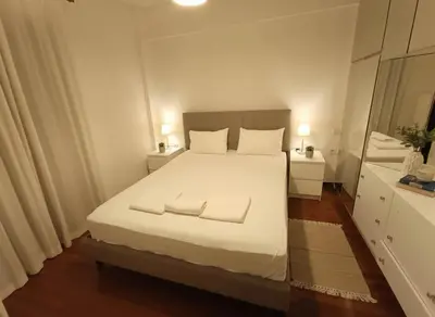 a bedroom with a white bed with two towels on it at Modern Ease by the CoastFaliro 2Bed Gem in Athens