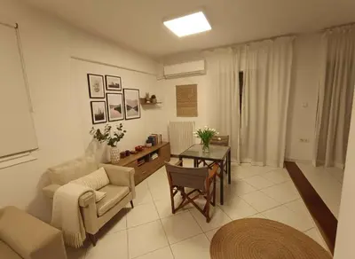 a living room with a couch and a table at Modern Ease by the CoastFaliro 2Bed Gem in Athens