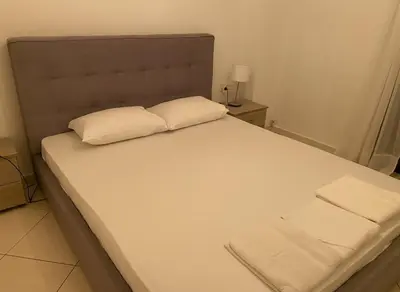 a bed with two pillows on it in a room at Modern Ease by the CoastFaliro 2Bed Gem in Athens