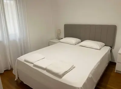 a bedroom with a white bed with two towels on it at Modern Ease by the CoastFaliro 2Bed Gem in Athens
