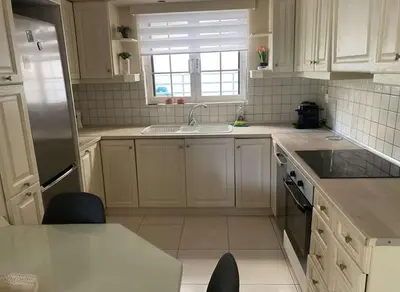 a kitchen with white cabinets and a sink and a window at Modern Ease by the CoastFaliro 2Bed Gem in Athens